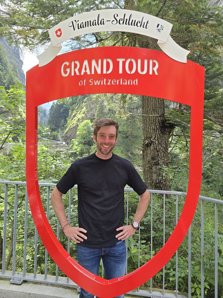 Josh standing in a Grand Tour of Switzerland photo frame at Viamala Gorge